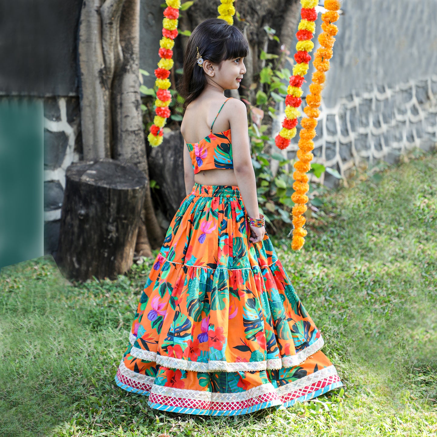 Girls Beautifully Crafted Orange Pleated Spaghetti Strap Top And Printed Layered Lehenga